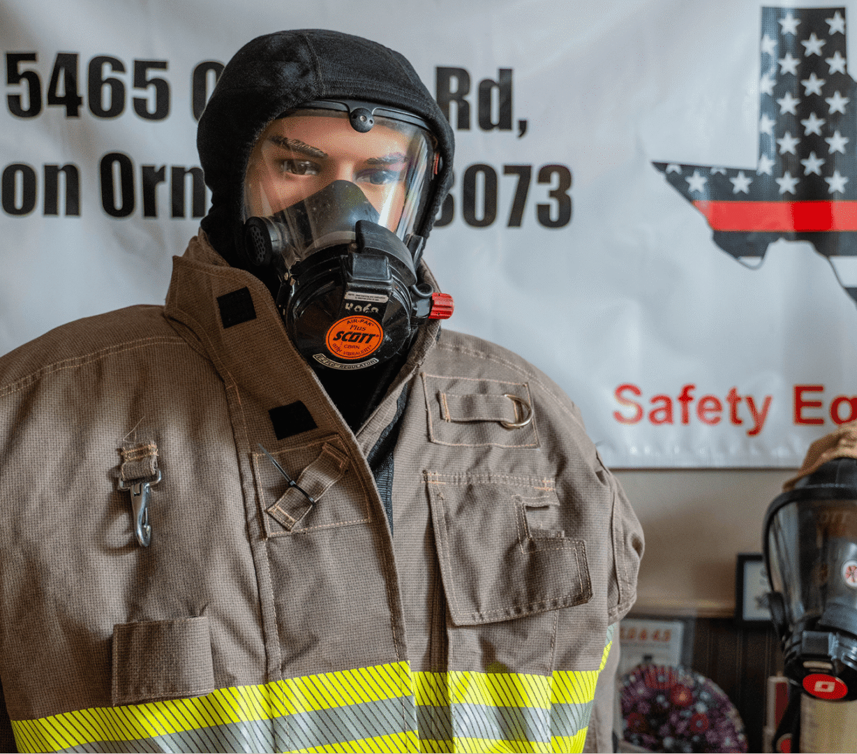 Firefighter mannequin wearing protective gear and mask.